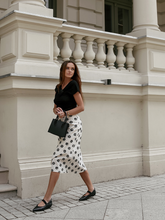 a lady wears a floral printed skirt with a black top
